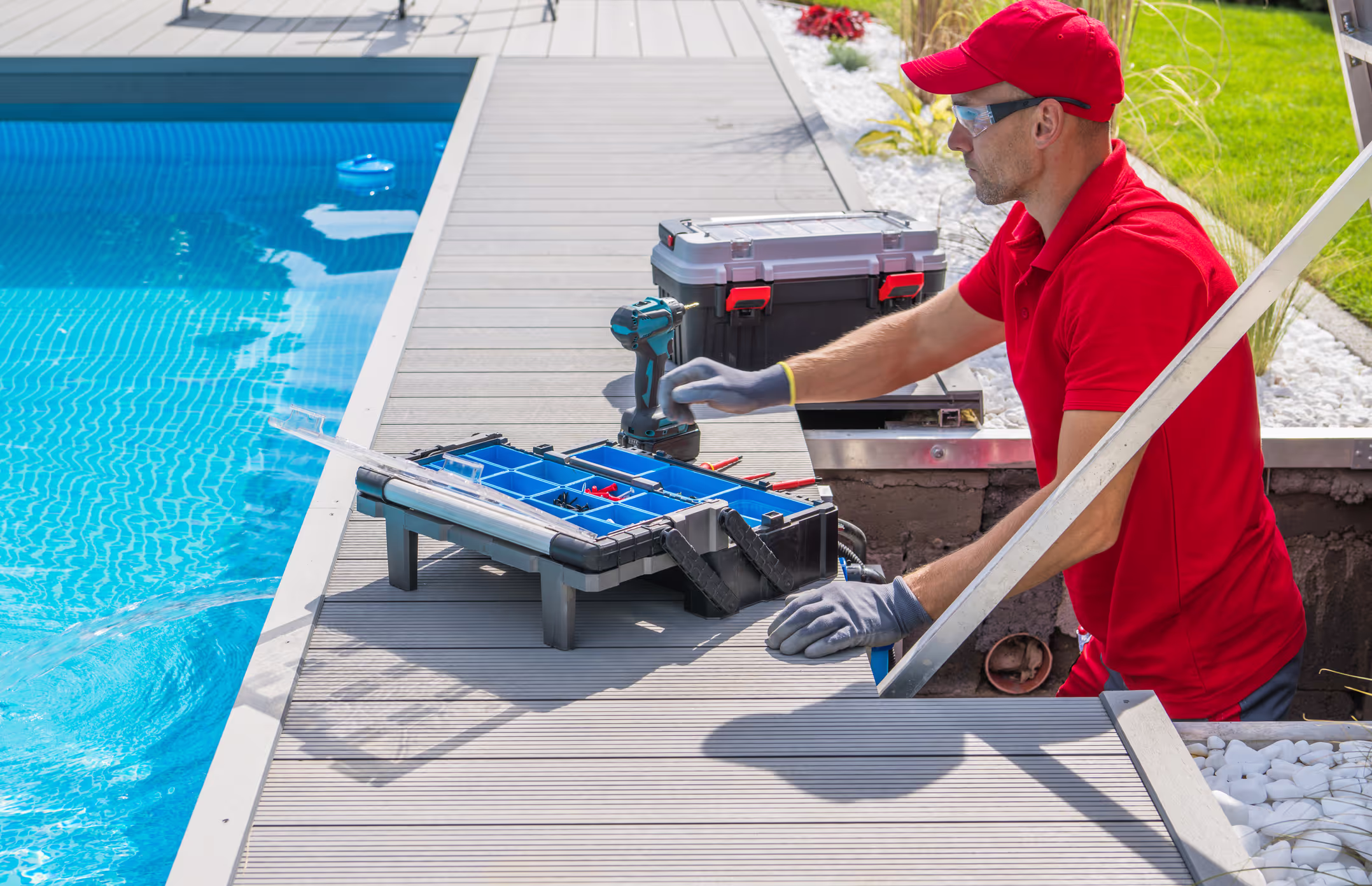 A field service technician in a red shirt using a handheld tool on the job.